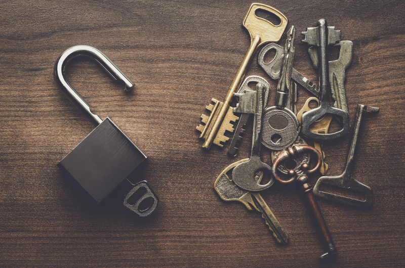 opened check-lock and different keys on wooden background concept
